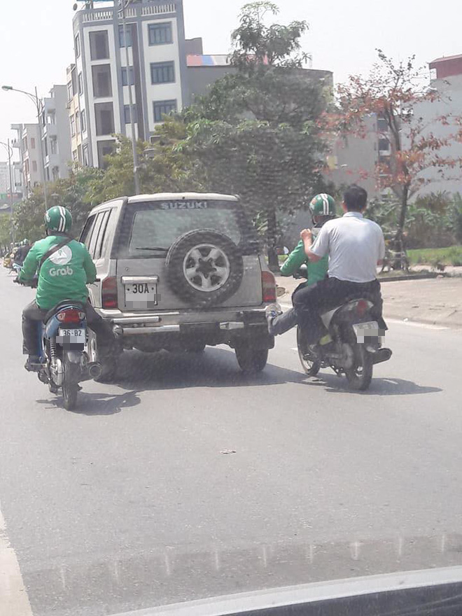 Tình huống hy hữu: 2 tài xế mặc đồng phục GrabBike chung chân đẩy một ô tô chết máy đi bon bon trên đường - Ảnh 1. Tình huống hy hữu: 2 tài xế mặc đồng phục GrabBike chung chân đẩy một ô tô chết máy đi bon bon trên đường 1