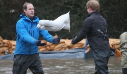 Hoàng tử Anh bì bõm cứu trợ lũ lụt