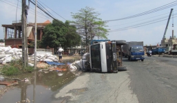 Xe tải lật, người dân giúp tài xế gom hàng