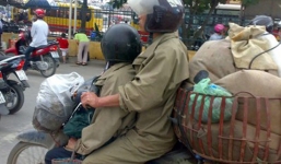 Ngồi sau vòng tay ra trước lái xe máy có vi phạm luật?