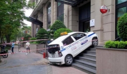 Mất lái, taxi 'bay' lên thềm nhà giữa phố