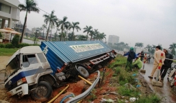 Mất lái, xe container chở máy giặt lật xuống kênh