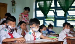 Học sinh tiểu học bịt khẩu trang ngồi học