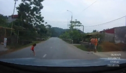 Video: Em bé Hà Giang lao qua đường quốc lộ suýt bị ô tô cán