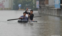 Người dân Trung Quốc bơi thuyền trên đường phố ngập nước