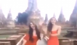 2 cô gái mặc váy ngắn, nhảy múa khêu gợi ngay trước cửa đền Thái Lan