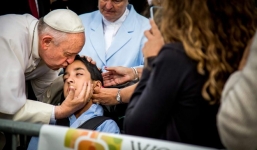 Giáo hoàng bất ngờ dừng xe, cúi người hôn cậu bé bại não