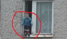 Video sốc: Bé trai nghịch ngợm treo mình trên cửa số tầng 8