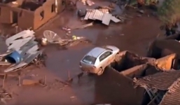 Ô tô bị lũ cuốn lên nóc nhà sau thảm họa vỡ đập ở Brazil