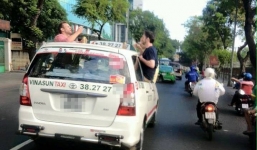 Du khách Tây nhậu trên nóc xe taxi đang chạy ở Sài Gòn