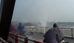 Người đi đường phải mặc áo mưa giữa trời nắng khi qua cầu