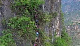 Học sinh TQ leo vách núi dựng đứng 800 mét đến trường