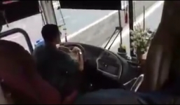 Tài xế xe khách vừa lái xe vừa ăn bánh tráng cuốn