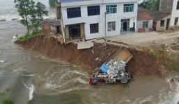 Video: 10 xe tải lao xuống dòng nước lũ để cứu đê vỡ ở Trung Quốc