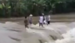 Người dân giải cứu 2 thanh niên cùng xe máy dưới dòng lũ chảy xiết