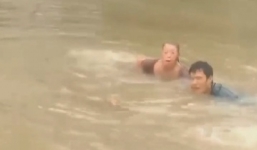 Video: Chàng trai nhảy xuống lũ dữ cứu người và chó mắc kẹt