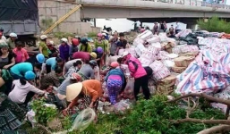 Xe chở hàng lật dưới chân cầu, người dân 'hôi của' trả tiền ủng hộ lái xe