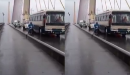 Gió mạnh trên cầu Bãi Cháy, xe máy được ô tô che chắn để di chuyển