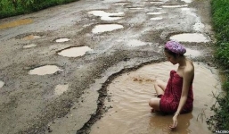 Người mẫu Thái tắm giữa ổ gà để phản đối đường lầy lội