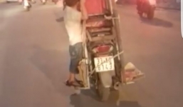 Rùng mình cậu bé 5 tuổi bám vào khung gỗ trên xe máy đang chạy