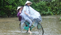 Hoa hậu Phạm Hương chạy xe đạp chở cụ già trong cơn mưa dầm