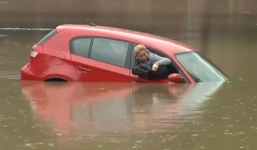 Nữ tài xế trèo lên nóc xe bị chìm giữa đường cầu cứu