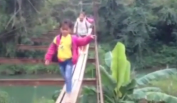 Học sinh men theo dải gỗ chênh vênh bắc qua suối đến trường