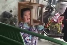 Vẻ mặt hài hước của cậu bé bị kẹt đầu vào ghế gỗ