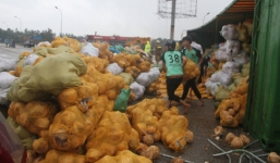 Lật xe container, người dân đội mưa gom 30 tấn dưa giúp tài xế