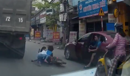 Ôtô mở cửa làm 2 em nhỏ suýt rơi vào gầm xe tải