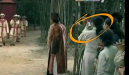 Diễn viên quần chúng phim cổ trang hồn nhiên dùng điện thoại