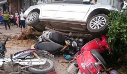 'Xế hộp' mất lái đâm đổ cây xanh, đè lên 4 xe máy trên vỉa hè