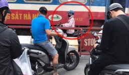 Thót tim khoảnh khắc cô gái cố tình băng qua đường tàu, bị mắc kẹt giữa đoàn tàu đang chạy và rào chắn