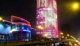 Người đi đường thích thú với tòa nhà tỏa sáng hình quốc kỳ đỏ rực cổ vũ U23 Việt Nam