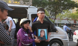 Người thân mang theo di ảnh nạn nhân nhìn về phía chung cư Carina lần cuối