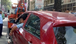 Tài xế 'cố thủ', hút thuốc trong ô tô dù xe bị kéo đi vì đậu sai quy định