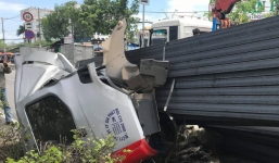 Hàng trăm thanh đà thép bị rơi, hất phần cabin container và tài xế bay xuống đường