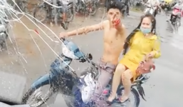 Bị ôtô chạy bắn nước bẩn lên người, nam thanh niên chở bạn gái đuổi theo cầm gạch ném vỡ kính xe