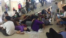 Ảnh: Người nhà bệnh nhân vạ vật gần hành lang, dưới bóng cây trong bệnh viện để tránh nắng đỉnh điểm trên 40 độ ở Hà Nội