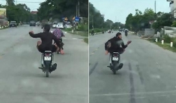 Nam thanh niên lái xe máy bằng chân, vừa đi vừa múa trên đường