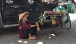 Hình ảnh bà cụ bán hàng rong ngồi nghỉ dưới bóng râm giữa cái nắng 'cháy da cháy thịt' của Thủ đô khiến nhiều người thương cảm