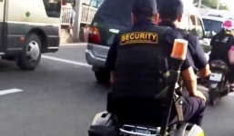 Bảo vệ nghênh ngang cầm súng, không đội mũ bảo hiểm đi trên phố
