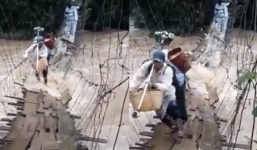 Người dân Lâm Đồng liều mình bám cầu treo lắc lư vượt lũ dữ