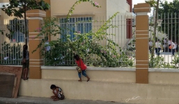 Hình ảnh 3 em nhỏ bán vé số bám hàng rào trường học để xem khai giảng gây xúc động mạnh