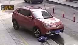 Cô gái mải mê ngồi nghịch điện thoại trên vỉa hè bị ô tô cuốn vào gầm