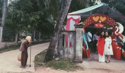 2 cô gái xinh đẹp chụp ảnh ở cổng rạp cưới nhưng hình ảnh cụ bà chống gậy đứng bên đường lại khiến nhiều người chú ý