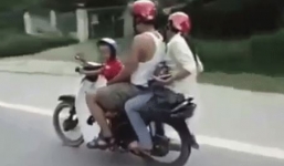 Bé trai 4 tuổi lái xe máy chở bố mẹ đi trên đường