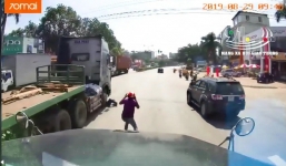 Khoảnh khắc kinh hoàng 2 người đàn ông vật lộn dưới bánh xe container