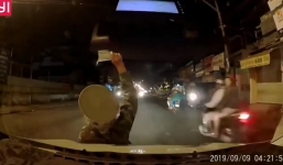 Người phụ nữ chặn đầu ôtô, nằm lên nắp capo múa may để bán vé số