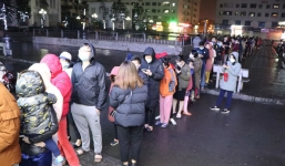 Mặc trời mưa lạnh, hàng trăm cư dân ở Hà Nội xếp hàng đến đêm để mua khẩu trang